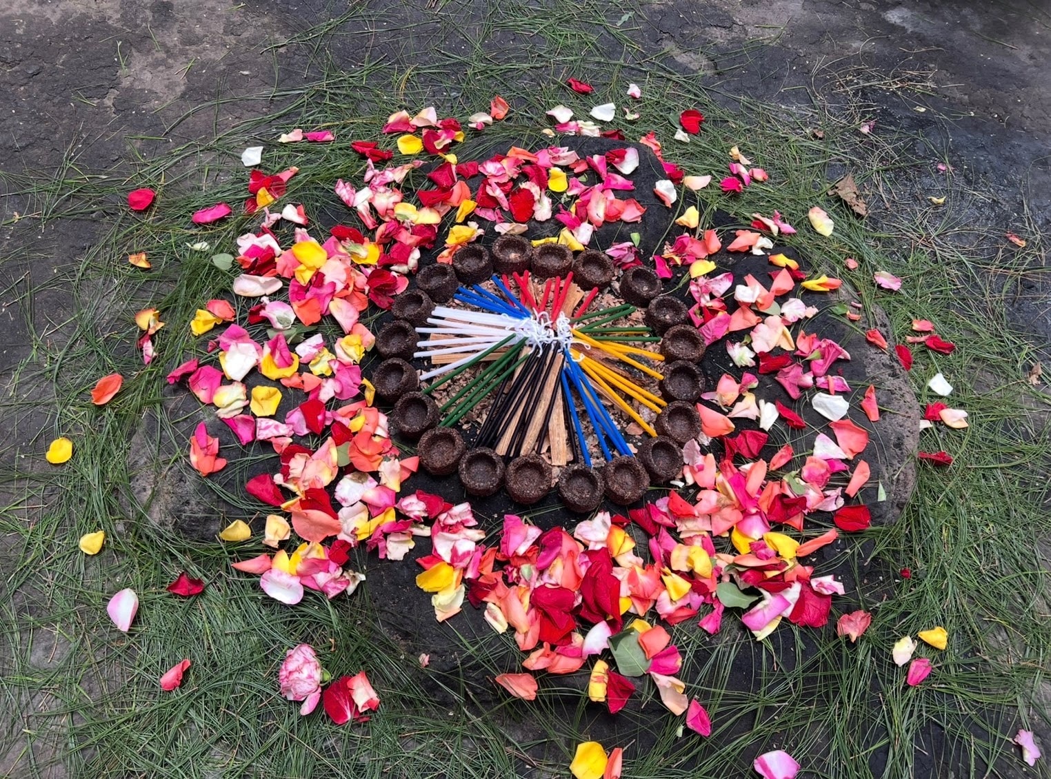 Candles arranged in a circle with flower petals