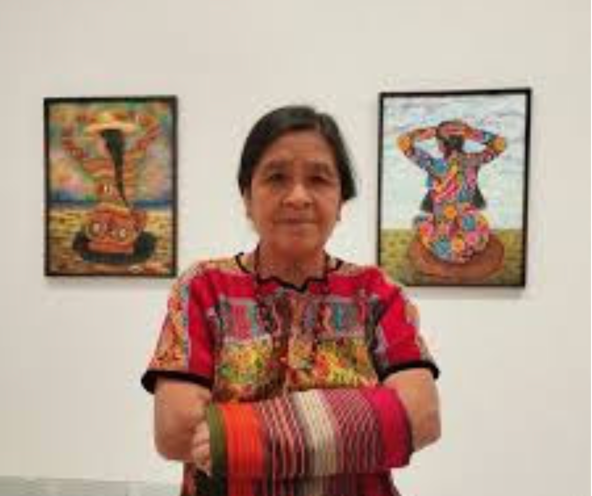 Paula Nicho Cúmez standing in front of her paintings
